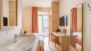 Habitación de hotel con baño amplio, escritorio, silla y cama.