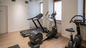 Un gimnasio en casa con cinta de correr, elíptica y bicicleta estática.