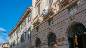 Un bâtiment historique à l’architecture classique, caractérisé par des fenêtres en arc et des détails sculptés dans la pierre.