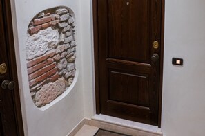A door with a brick wall design, a wooden door, and a doorknob. - Modern and comfortable house 30 meters from the Arena (Verona)