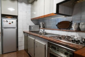 A compact kitchen with a built-in microwave, a stainless steel sink, and a gas stove.