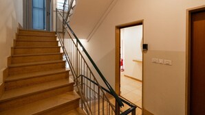 A staircase with a metal railing, a door at the top, and a light switch on the wall. - Large Filippini Residence a few meters from the Arena (Verona)