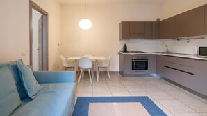 A compact living space with a kitchenette, a dining area, and a sofa. - Large Filippini Residence a few meters from the Arena (Verona)