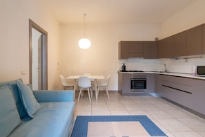 A compact living space with a kitchenette, a dining area, and a sofa.