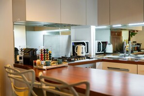 A modern kitchen with a central island, a microwave, a kettle, and a coffee maker. - Magnificent Residence overlooking Piazza Erbe (Verona)