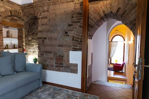 A living room with a brick wall, a sofa, and a rug. - Magnificent Residence overlooking Piazza Erbe (Verona)