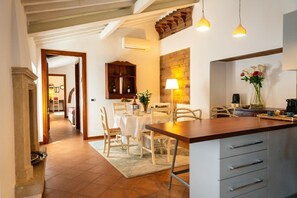 A kitchen with a dining area, featuring a wooden table, chairs, and a kitchen counter.
