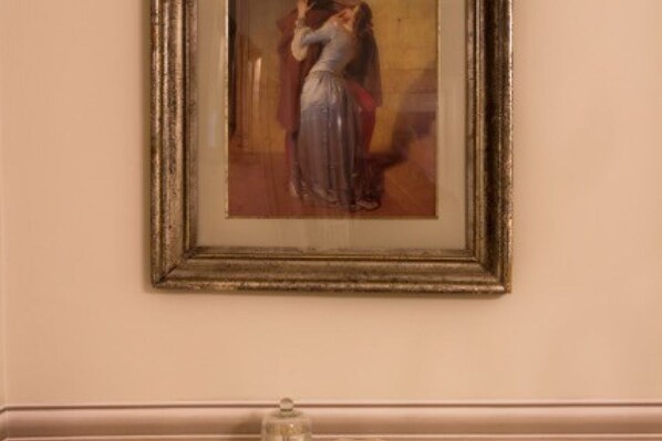 A framed painting of a couple dancing on a wall.