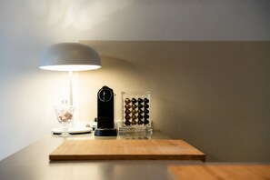A wooden table with a lamp, a clock, and a glass container with spherical objects. - A magnificent residence overlooking Piazza Erbe (Verona)