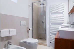 A modern bathroom with a glass shower enclosure, a toilet, a sink, and a towel rack. - Magnificent Residence overlooking Piazza Erbe (Verona)