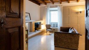 Ein Wohnzimmer mit Kamin, Sofa und Sessel.