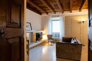 A living room with a fireplace, a sofa, and a chair. - Magnificent Residence overlooking Piazza Erbe (Verona)