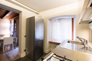 Une cuisine compacte équipée d’un réfrigérateur intégré, d’un évier et d’un coin repas avec des chaises.