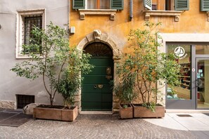 A building with a green door, stone archway, and potted plants.