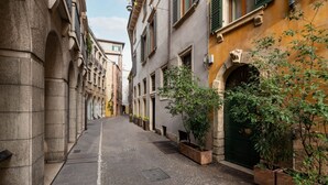 A narrow cobblestone street lined with historic buildings, featuring stone arches and traditional architecture. -  Modern Apartment 50 meters from Piazza Erbe (Verona)