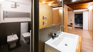 A modern bathroom with a large sink, toilet, bidet, and a mirror. -  Modern Apartment 50 meters from Piazza Erbe (Verona)