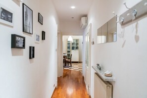 A hallway with framed pictures on the walls, a radiator, and a mirror with heart-shaped decorations. - Cozy Residence Rocchetto - 25 meters from P. Erbe (Verona)