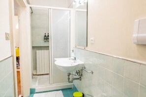 A bathroom with a white sink, a mirror, and a shower enclosure. - Cozy Residence Rocchetto - 25 meters from P. Erbe (Verona)