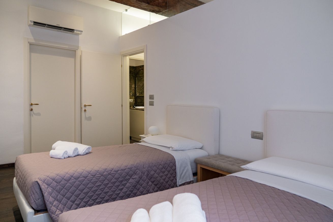 Une chambre d’hôtel avec deux lits, une salle de bain et un appareil de climatisation.