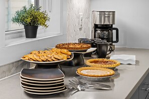 A kitchen with a coffee maker, a potted plant, and various food items on the counter.