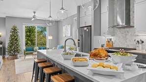 Una cocina moderna con una isla grande, electrodomésticos de acero inoxidable y vistas al exterior.