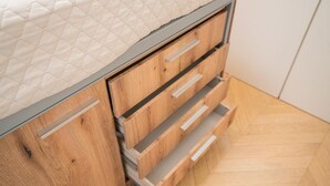 Un mueble de madera con cajones y un colchón.