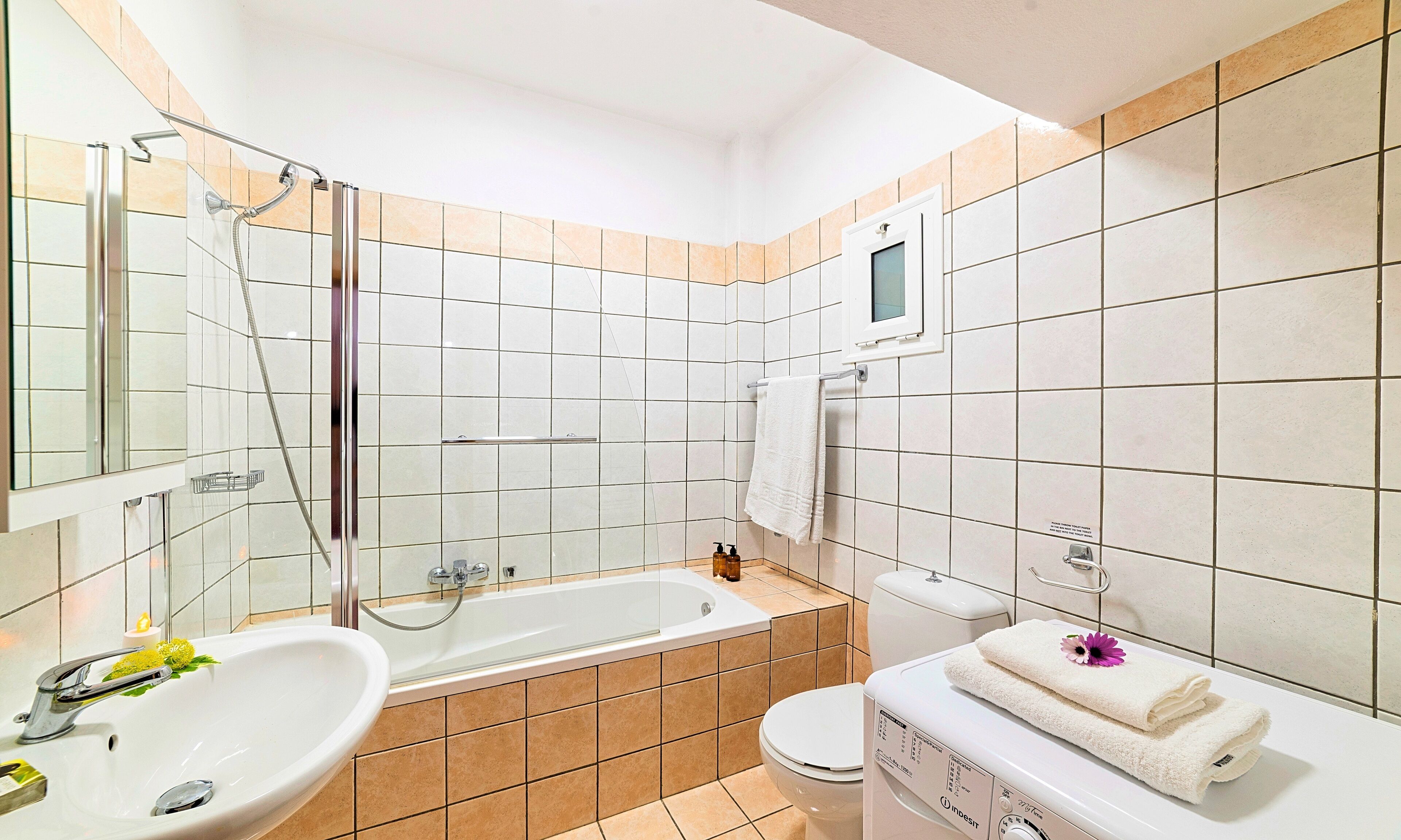 Ein Badezimmer mit einer Badewanne, einer Toilette, einem Waschbecken und einem Spiegel.