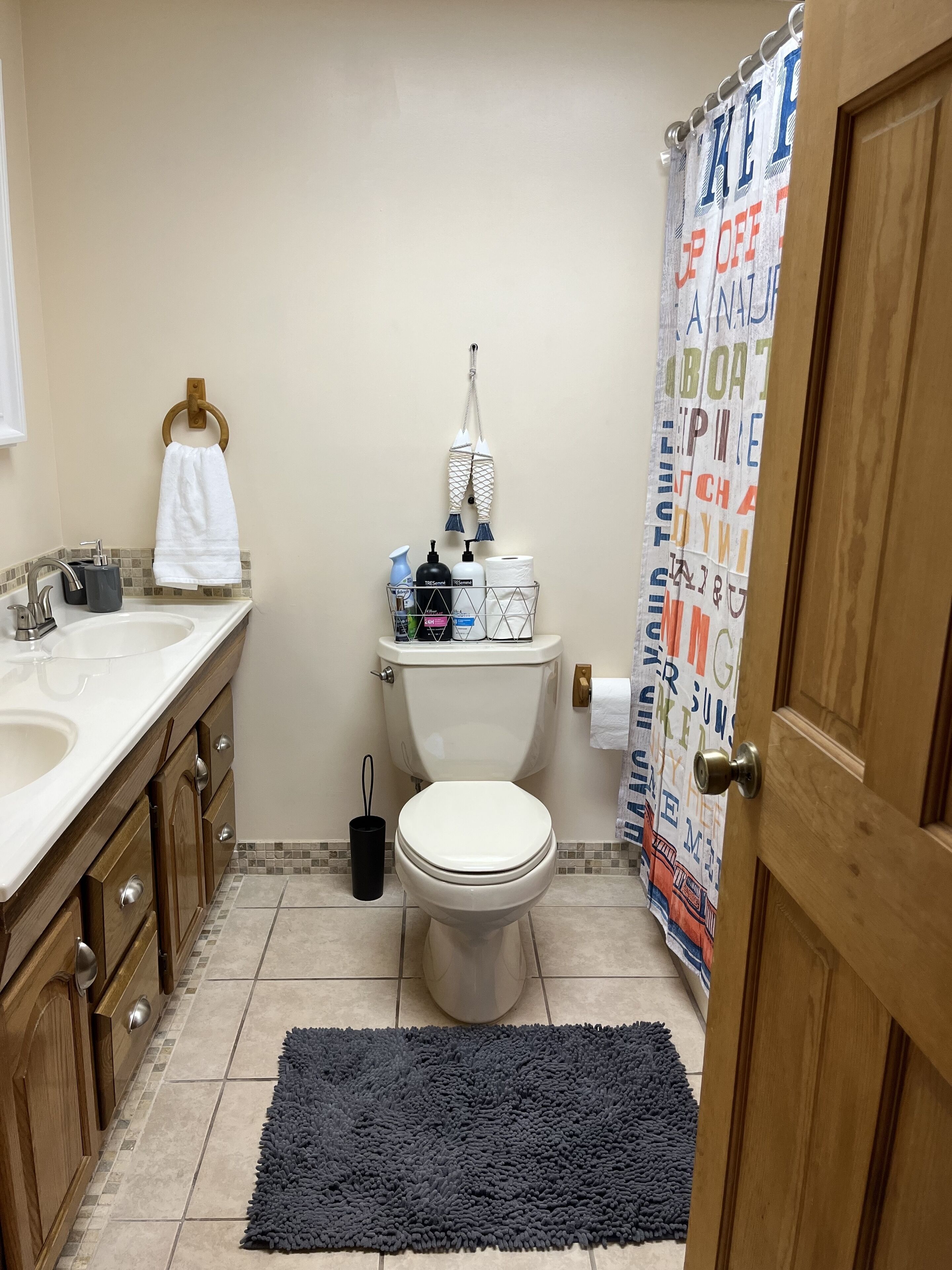 A bathroom with a toilet, sink, and shower curtain.