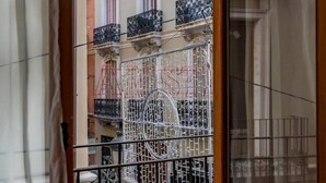 A view of a building with ornate balconies and a metal gate.