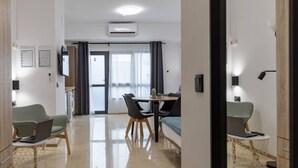 Une chambre d’hôtel moderne comprenant un coin repas, un lit et une salle de bain.