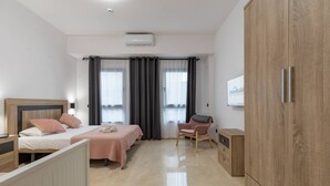Una habitación de hotel moderna con dos camas, una silla, un armario y un televisor de pantalla plana.