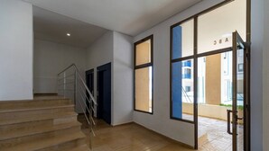 A modern interior with a wooden staircase, large windows, and a glass door leading outside. - Heliopolis with sea views. (Benicàssim)