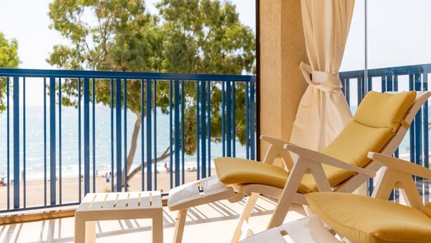 A balcony with a view of the sea and trees, featuring two sun loungers and a small table. - Heliopolis with sea views. (Benicàssim)