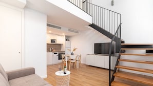 A modern apartment with a living room, kitchen, and a staircase. - Alameda suites loft 1. (Valencia / València)