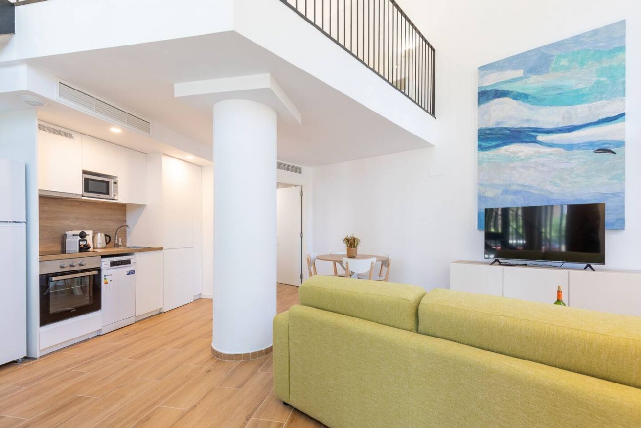 A modern apartment with a kitchen, dining area, and living room.
