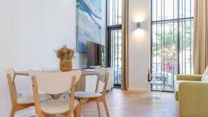 Een moderne woonkamer met een eethoek, grote ramen en uitzicht op het omliggende landschap.
