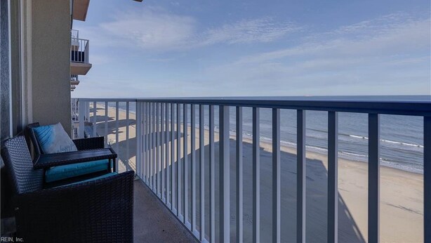 En balkon med udsigt over stranden og havet.