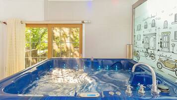A hot tub with a digital control panel, a window with curtains, and a wall with a vintage car illustration.