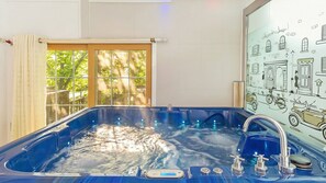 A hot tub with a digital control panel, a window with curtains, and a wall with a vintage car illustration. - Gapyeong Belita Pension (Gapyeong)
