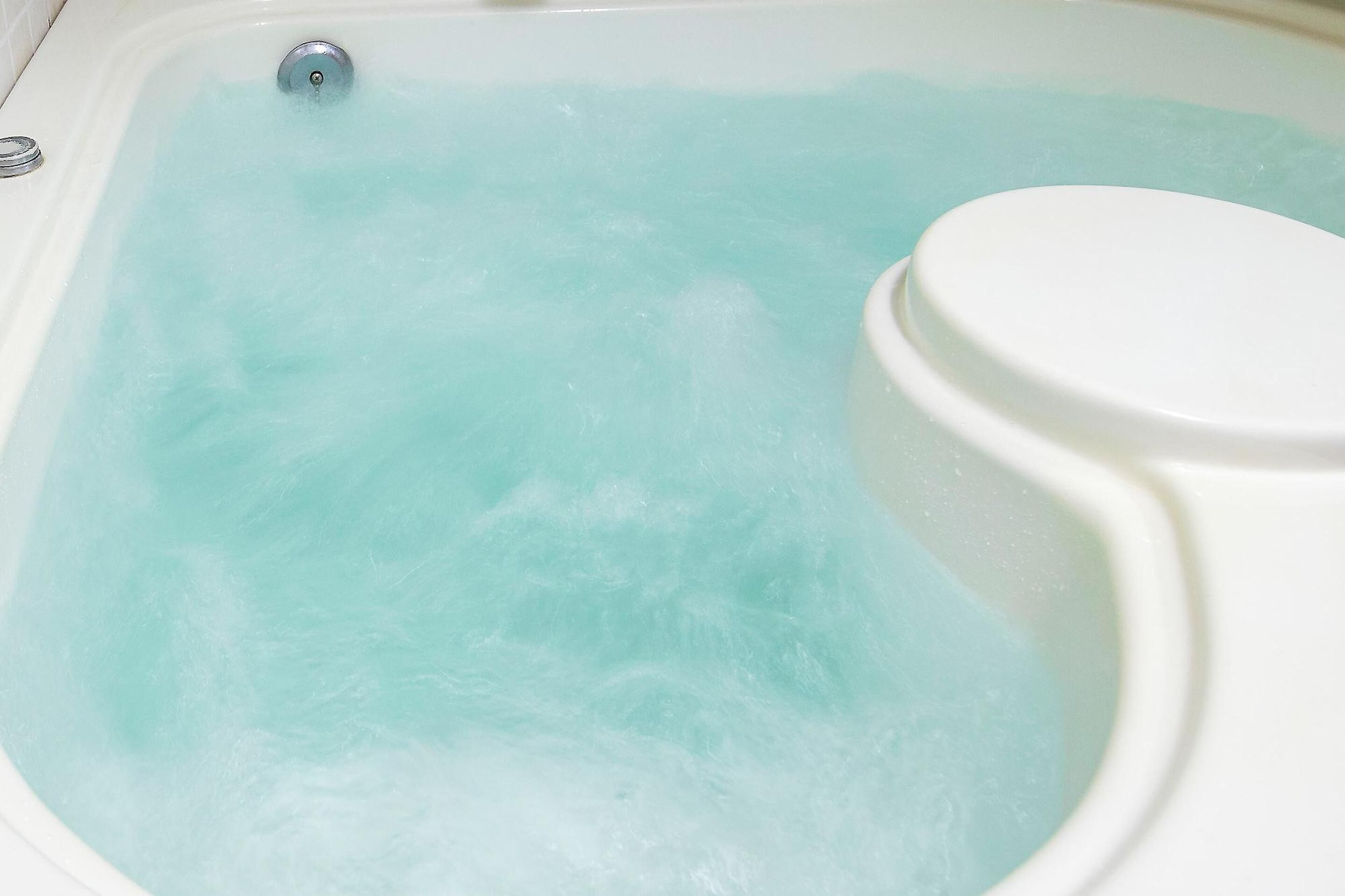 A bathtub filled with clear water.