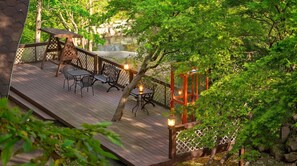 A wooden deck with outdoor furniture and a lantern. - Gapyeong Belita Pension (Gapyeong)