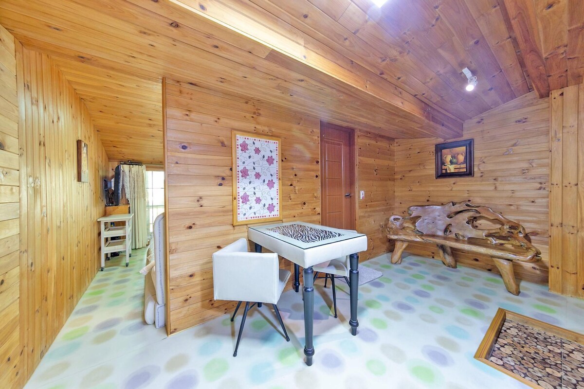 A wooden cabin interior with a table, a bench, and a door.
