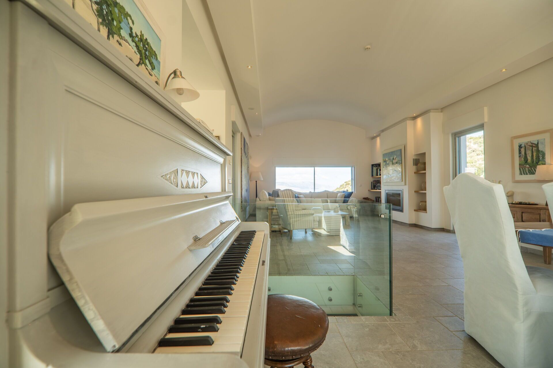 A spacious living area with a grand piano, a glass coffee table, and a comfortable seating arrangement.