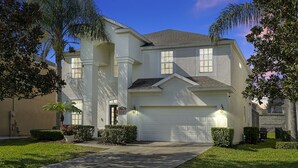 A two-story house with a white exterior, a garage, and a well-maintained lawn. - Luxurious home 2 miles from  Disney - Windsor Hills Resort (Kissimmee)