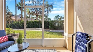 Una habitación con un ventanal curvo que da a un jardín y árboles.