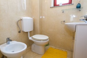 Een douche, handdoeken, toiletpapier