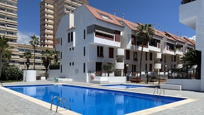 A swimming pool with a clear blue water surface, surrounded by a tiled deck. - 2 BED DUPLEX APARTMENT IN THE HEART OF LAS AMERICAS (Playa Delas Americas)
