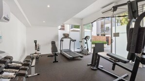 Ein modernes Fitnessstudio mit Laufbändern, Crosstrainern und Kurzhanteln.