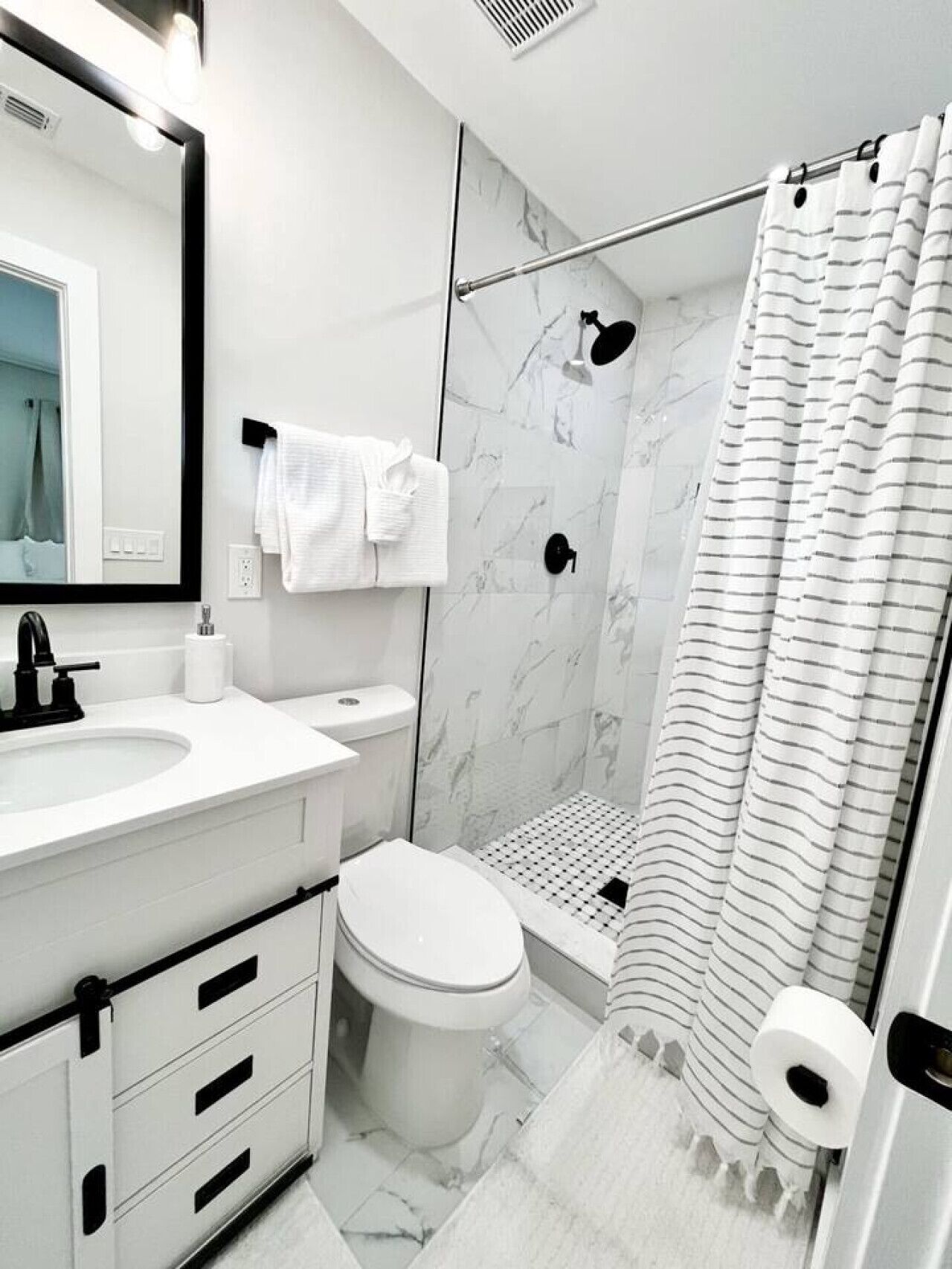 Een moderne badkamer met een wit wastafel, toilet en douche.