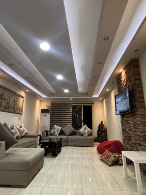 Apartamento City | Zona de estar | Televisión de pantalla plana de 50 pulgadas con canales por satélite